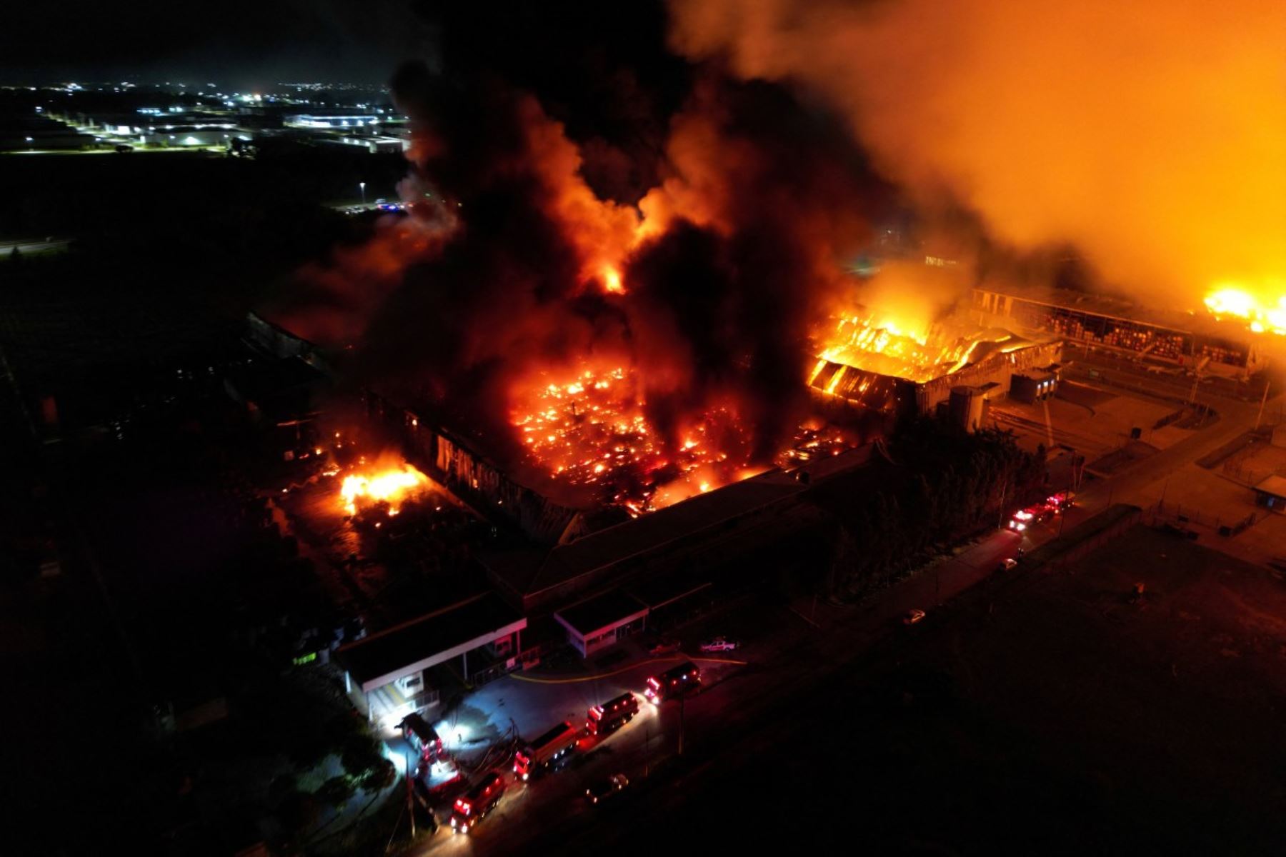 Una densa columna de humo negro y naranja se alza cientos de metros en el cielo del municipio de Ezeiza, a unos 40 kilómetros de Buenos Aires, mientras las llamas iluminan las inmediaciones de los edificios afectados. AFP