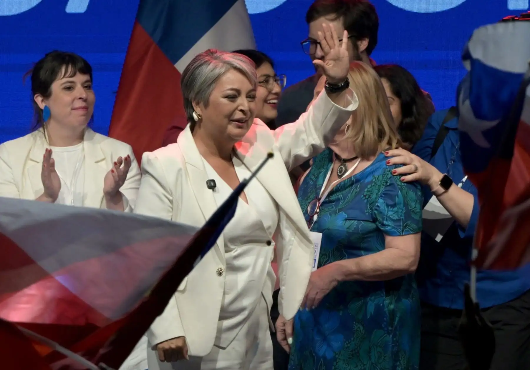 La candidata presidencial chilena Jeannette Jara, de la coalición Unidad por Chile, saluda a sus partidarios mientras pronuncia un discurso después de los resultados de la primera encuesta de salida de las elecciones generales, en Santiago el 16 de noviembre de 2025. (Foto de Rodrigo ARANGUA / AFP)