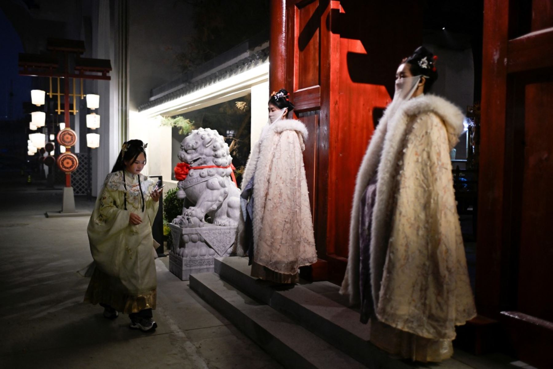 Mujer vestida con ropa tradicional china llegando a la entrada de un restaurante temático en Pekín. AFP