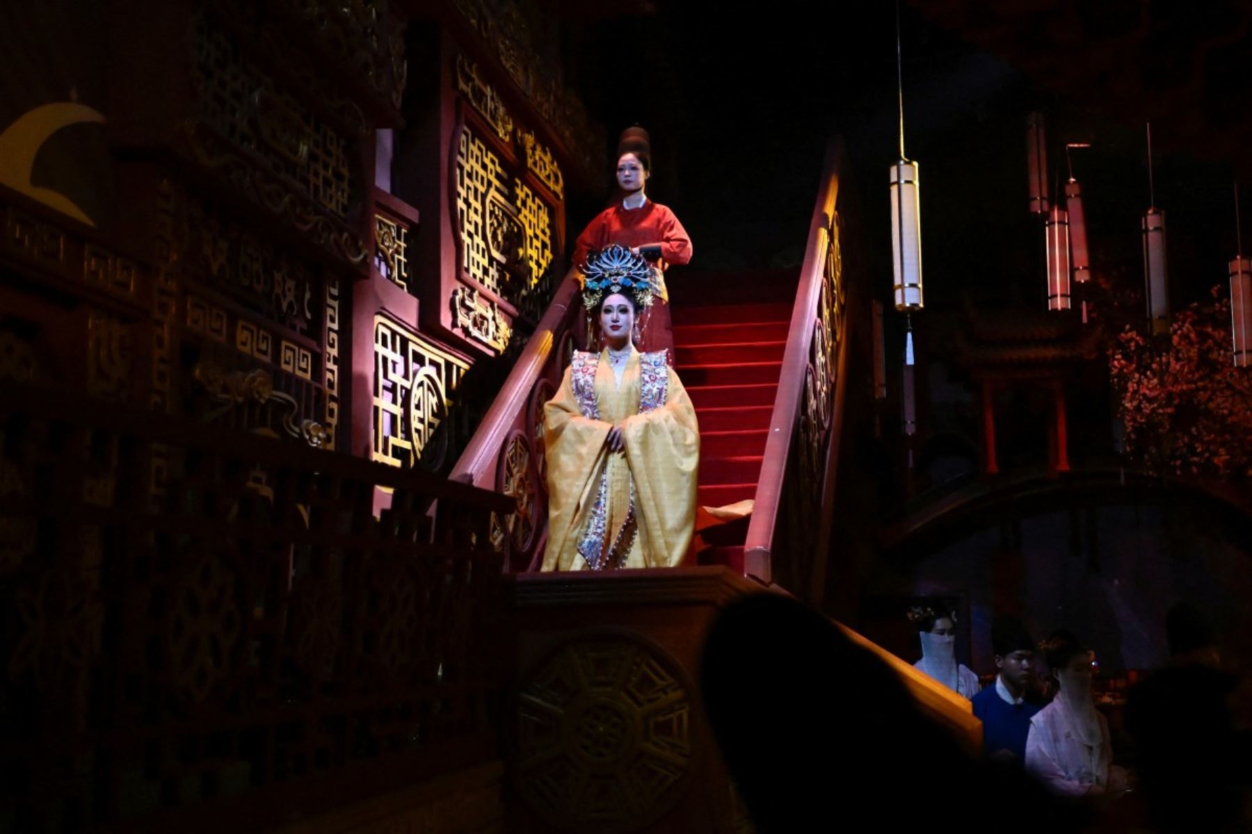 Mujeres con largas pelucas y elaborados vestidos tradicionales se movían por un patio empedrado, deteniéndose para tomarse fotos bajo un pabellón, mientras de fondo sonaba la melodiosa melodía de una cítara china. AFP