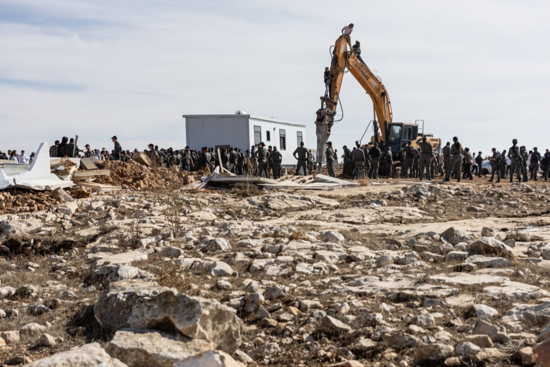 Jóvenes de Hilltop se subieron a una excavadora durante un enfrentamiento con las fuerzas de seguridad israelíes que evacuaban y demolían un puesto de avanzada  construido cerca del asentamiento judío de Metzad, al este de la ciudad palestina de Saiir, en la Cisjordania ocupada. Foto: AFP