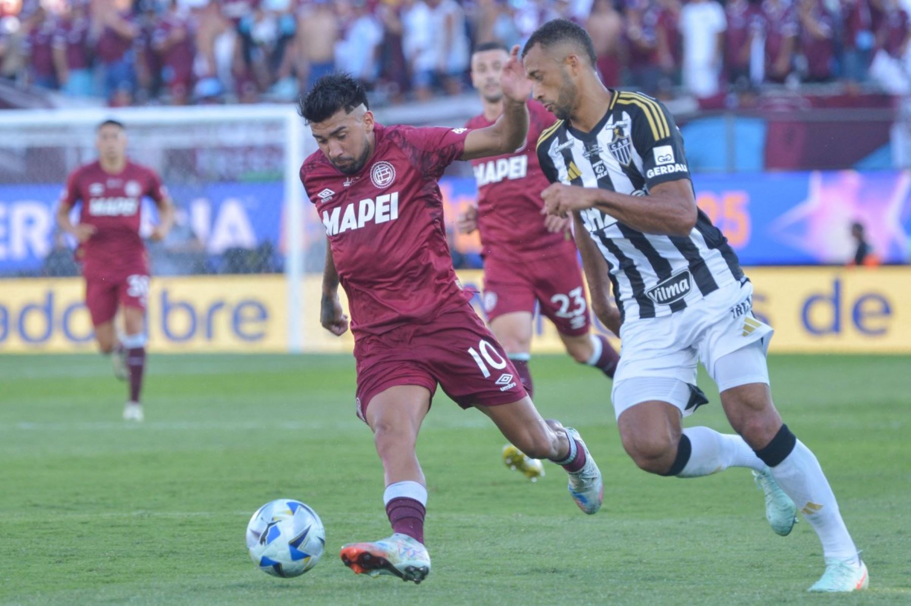 El centrocampista #10 de Lanus Marcelino Moreno y el defensor #14 del Atlético Mineiro Vitor Hugo luchan por el balón durante el partido final de fútbol de la Copa Sudamericana entre el Lanus de Argentina y el Atlético Mineiro de Brasil en el estadio de Defensores del Chaco en Asunción el 22 de noviembre de 2025. (Foto de DANIEL DUARTE / AFP)
