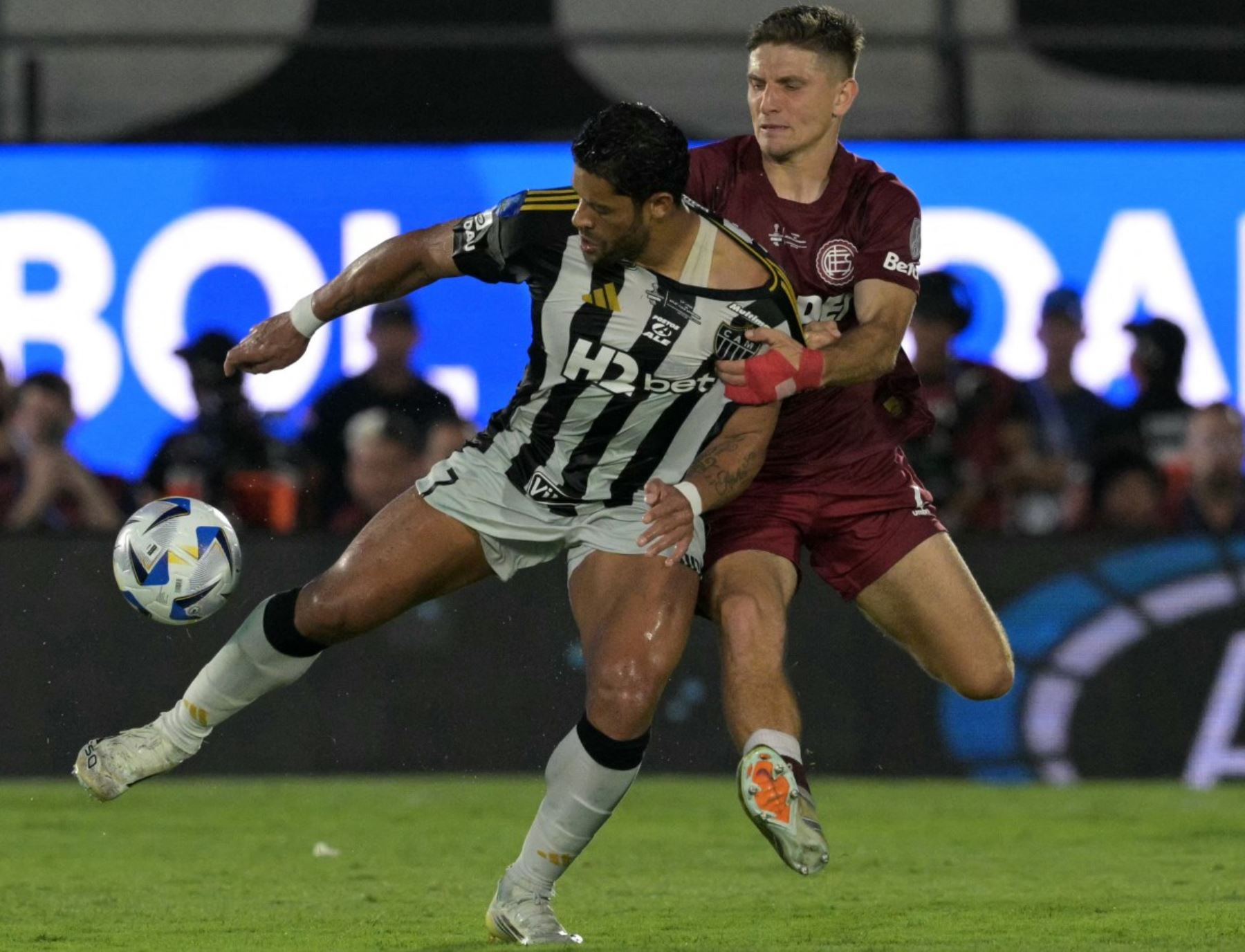 El delantero del Atlético Mineiro #07 Hulk (Ir) y el defensor #06 de Lanus Sasha Marcich (R) luchan por el balón durante el partido final de fútbol de la Copa Sudamericana entre el Lanus de Argentina y el Atlético Mineiro de Brasil en el estadio Defensores del Chaco en Asunción el 22 de noviembre de 2025. (Foto de JUAN MABROMATA / AFP)