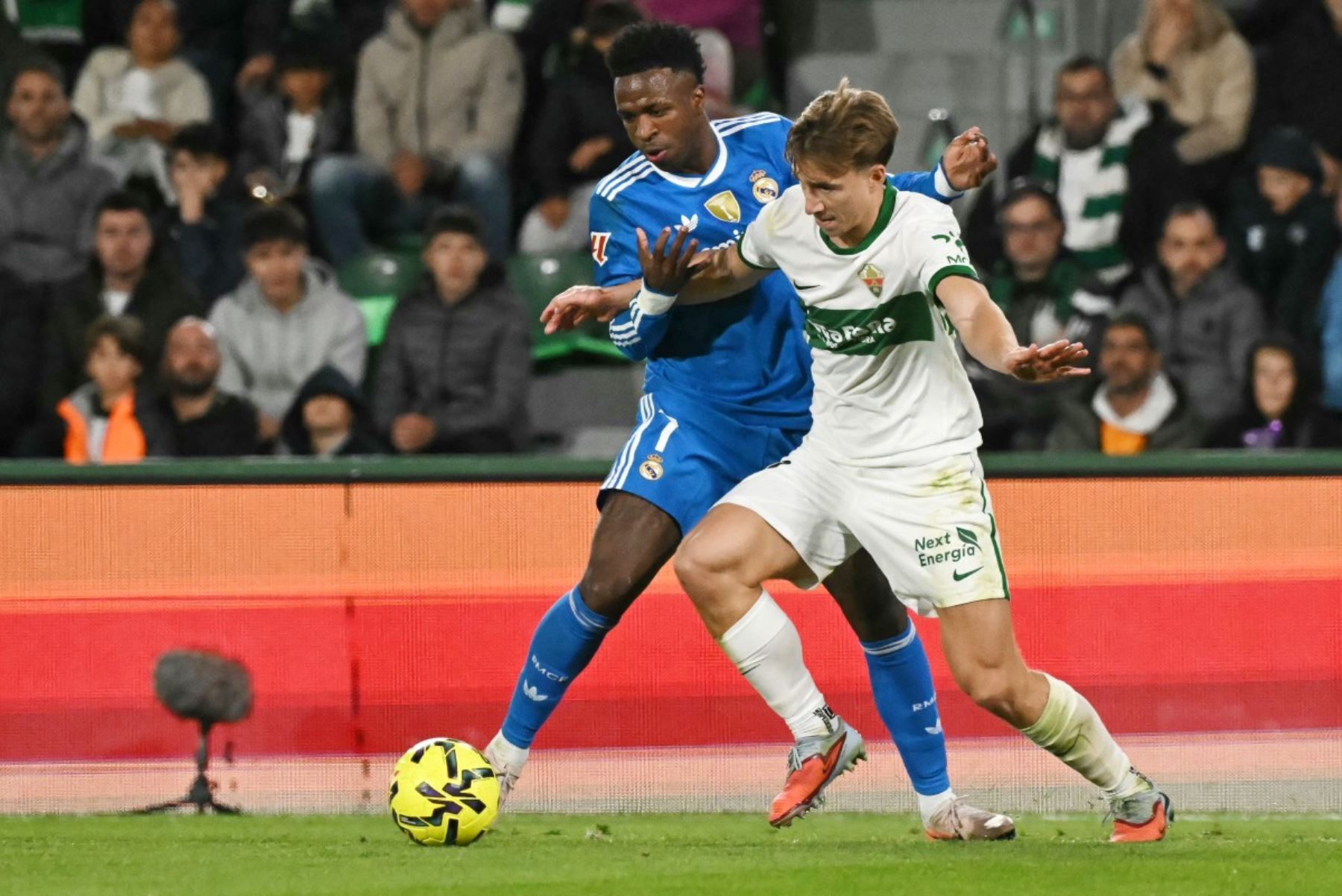 El delantero brasileño del Real Madrid #07 Vinicius Junior (L) lucha por el balón con el defensor austriaco del Elche #22 David Affengruber durante el partido de fútbol de la liga española entre Elche CF y el Real Madrid CF en el Estadio Martínez Valero en Elche el 23 de noviembre de 2025. (Foto de JOSE JORDAN / AFP)