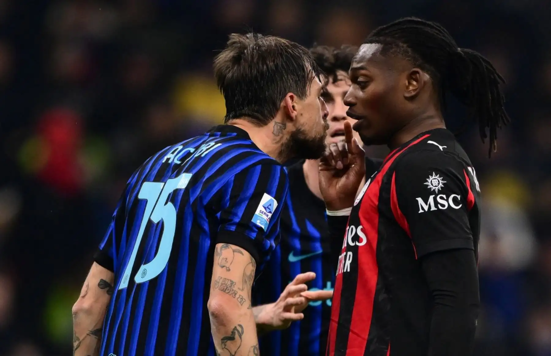 El delantero portugués #10 del AC Milán, Rafael Leao (R), reacciona mientras habla con el defensor italiano del Inter Milan #15 Francesco Acerbi (L) después de recibir una tarjeta amarilla durante el partido de fútbol de la Serie A italiana entre el Inter de Milán y el AC Milán en el estadio San Siro en Milán, norte de Italia, el 23 de noviembre de 2025. (Foto de Marco BERTORELLO / AFP)