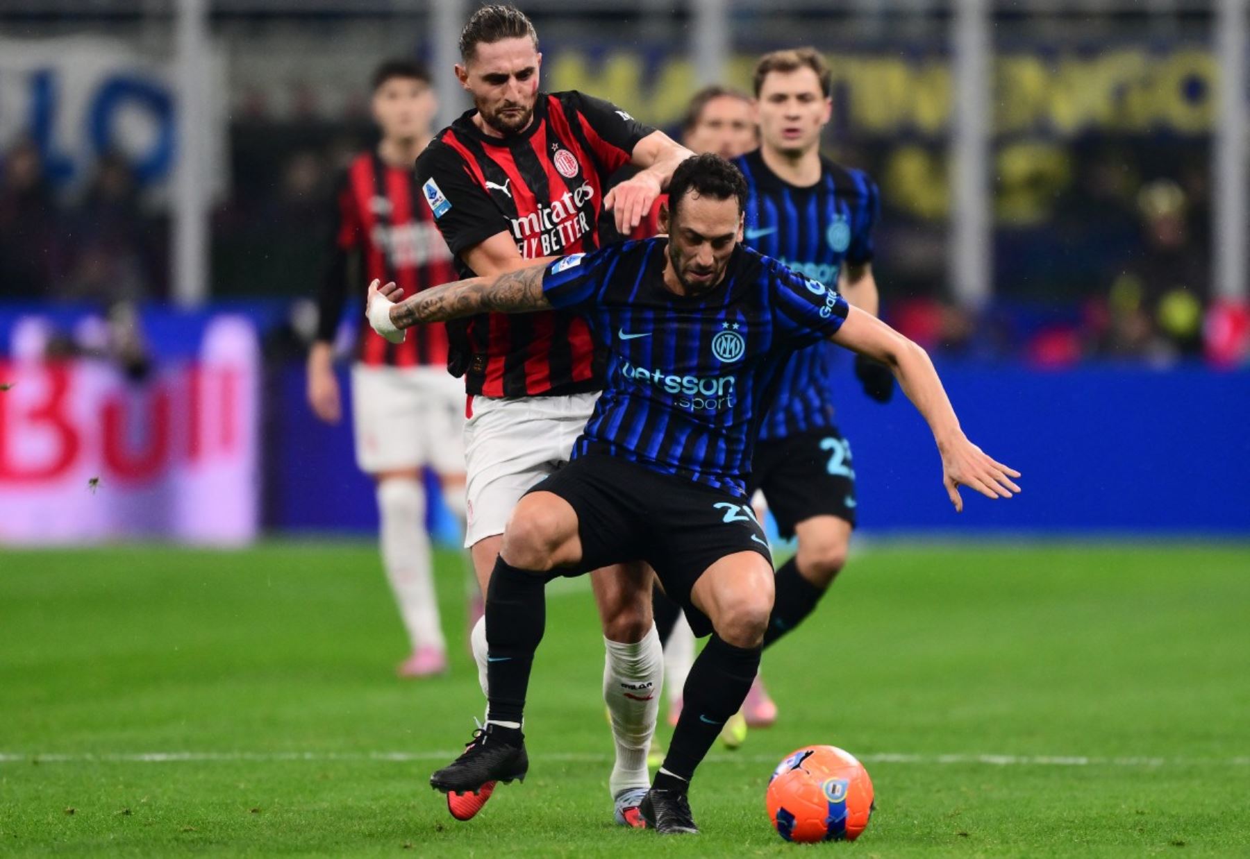 El centrocampista francés #12 del AC Milan Adrien Rabiot (L) y el centrocampista turco del Inter Milan #20 Hakan Calhanoglu durante el partido de fútbol italiano de la Serie A entre el Inter de Milán y el AC Milán en el estadio San Siro en Milán, norte de Italia, el 23 de noviembre de 2025. (Foto de Marco BERTORELLO / AFP)