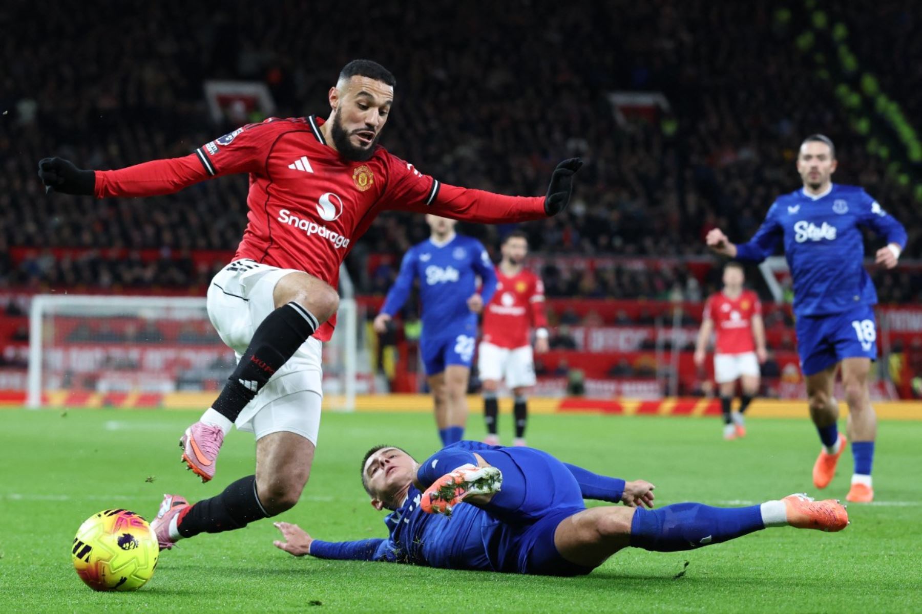 El defensa ucraniano  del Everton, Vitaliy Mykolenko  aborda al defensa marroquí  del Manchester United, Noussair Mazraoui , durante el partido de la Premier League inglesa entre el Manchester United y el Everton.