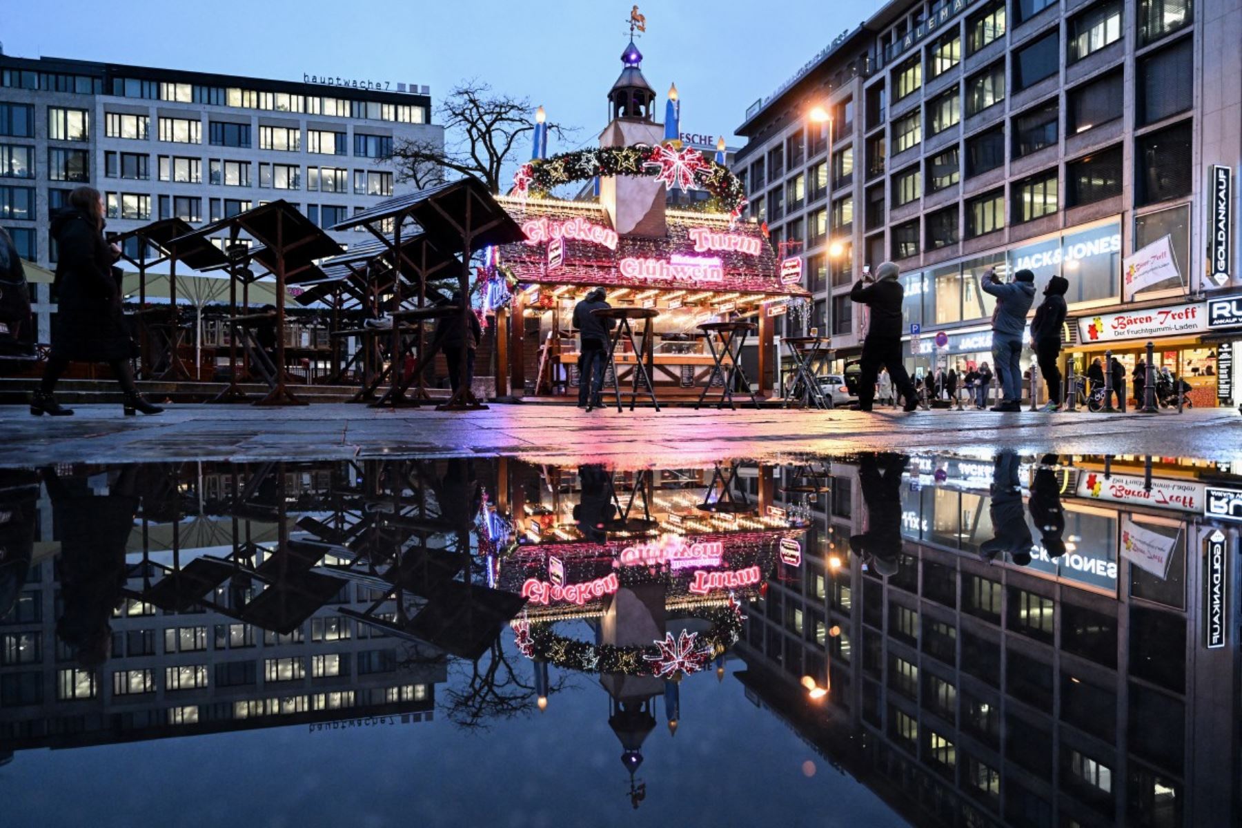 Las luces de un puesto recién instalado con adornos navideños se reflejan en la céntrica plaza Roemer de Frankfurt am Main, en el oeste de Alemania. AFP