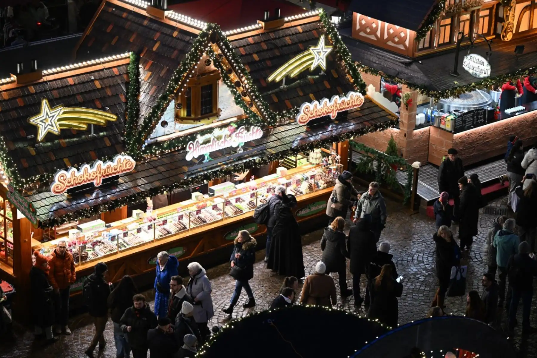 La gente pasa junto a un puesto de venta de dulces en el mercado navideño de la céntrica plaza Roemer de Frankfurt am Main. AFP