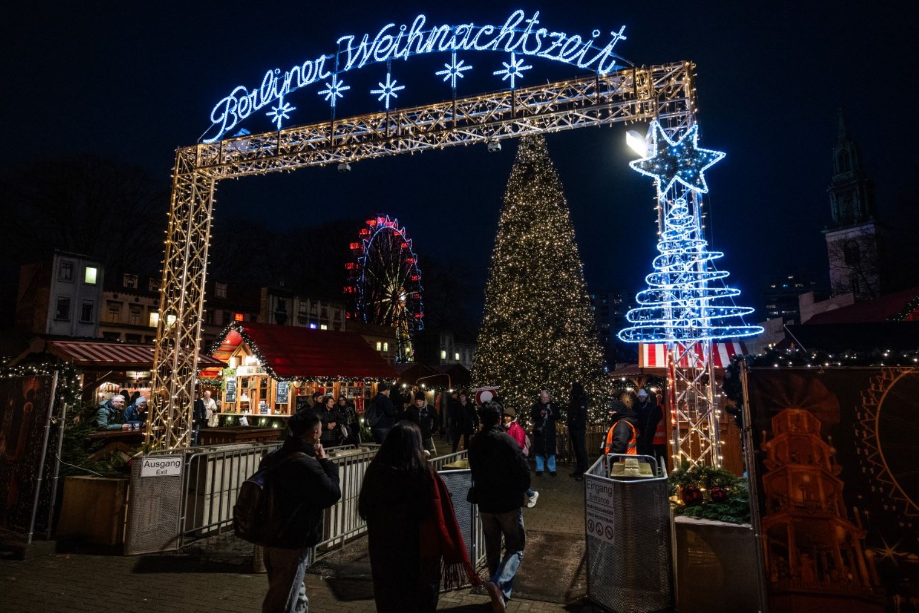 Las visitantes entran en un mercado de Navidad cerca del ayuntamiento de Berlín (Rote Rathaus). AFP