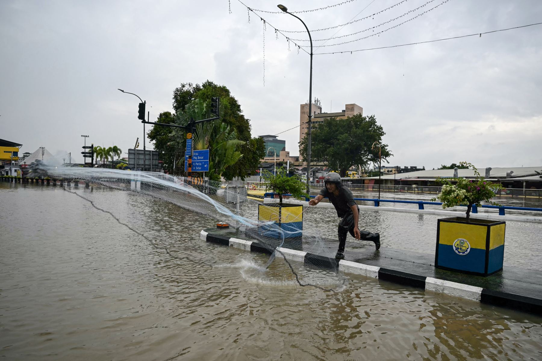 Un hombre lanza una red de pesca en las aguas de una zona urbana inundada en Kangar, en el estado de Perlis, al norte de Malasia. Las graves inundaciones afectaron a miles de personas en la región tras días de fuertes lluvias. Las inundaciones en Malasia, causadas por días de fuertes lluvias, han arrasado ocho estados, y los meteorólogos pronostican más lluvias en los próximos días.

Foto: AFP