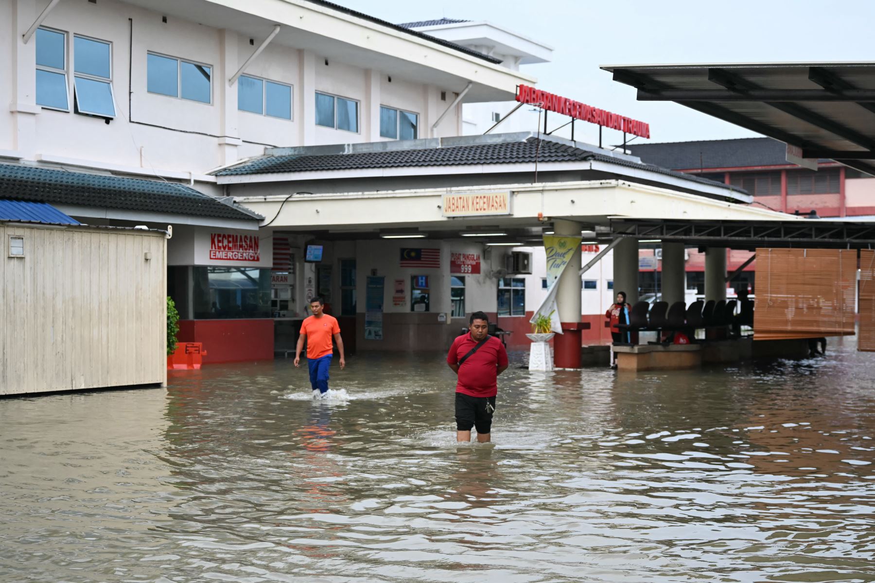 Personas caminan por el agua junto a un hospital inundado en Kangar, en el estado de Perlis, al norte de Malasia. Las graves inundaciones afectaron a miles de personas en la región tras días de fuertes lluvias. Las inundaciones en Malasia, causadas por días de fuertes lluvias, han arrasado ocho estados, y los meteorólogos pronostican más lluvias en los próximos días.

Foto: AFP
