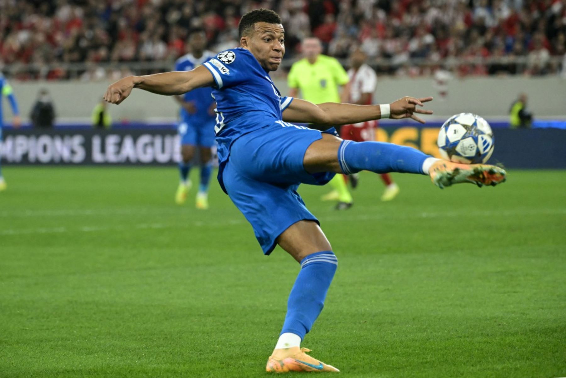 El delantero francés  del Real Madrid, Kylian Mbappé, dispara el balón durante la quinta jornada de la fase de liga de la UEFA Champions League, partido de fútbol entre Olympiakos  y Real Madrid. AFP