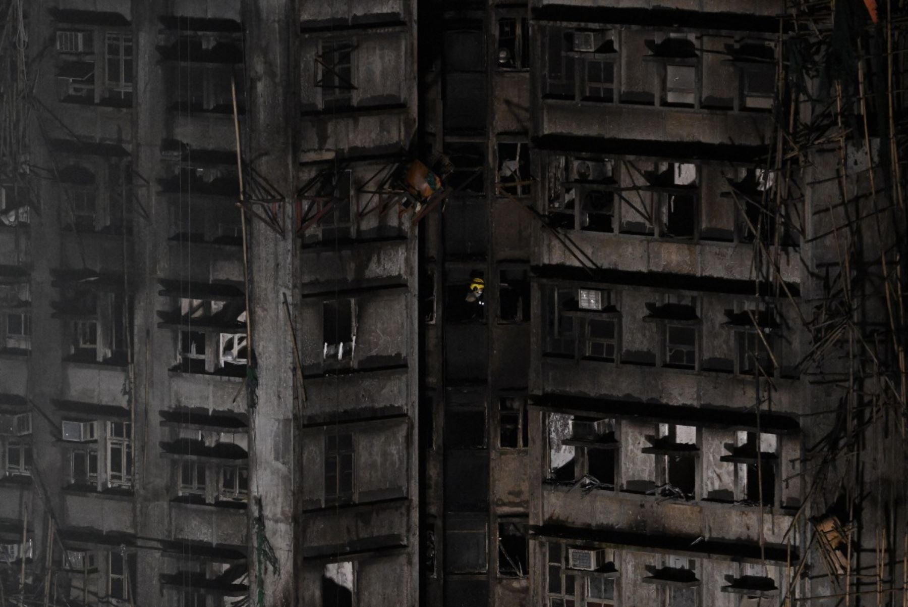 Un bombero camina dentro de un apartamento después de un gran incendio que arrasó varios bloques de apartamentos en el complejo residencial Wang Fuk Court en el distrito Tai Po de Hong Kong. Foto: AFP