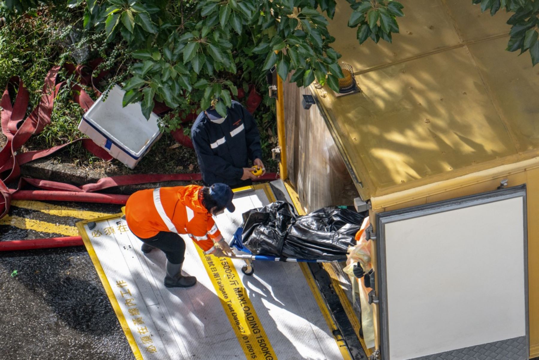 Un cuerpo es trasladado a un vehículo después de un gran incendio que arrasó varios bloques de apartamentos en el complejo residencial Wang Fuk Court en el distrito Tai Po de Hong Kong. AFP