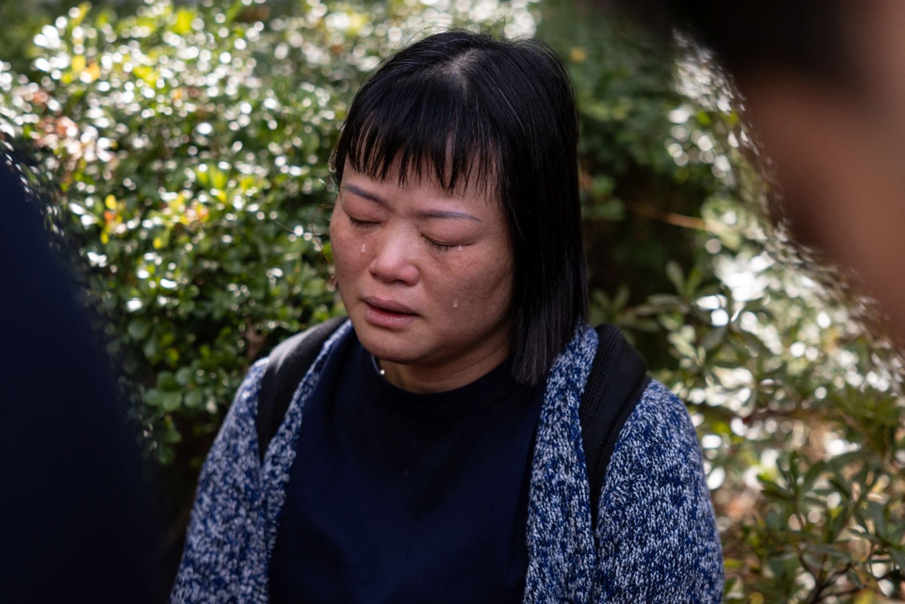 Una residente reacciona mientras habla con los medios tras un gran incendio que arrasó varios bloques de apartamentos en el complejo residencial Wang Fuk Court, en el distrito Tai Po de Hong Kong. AFP