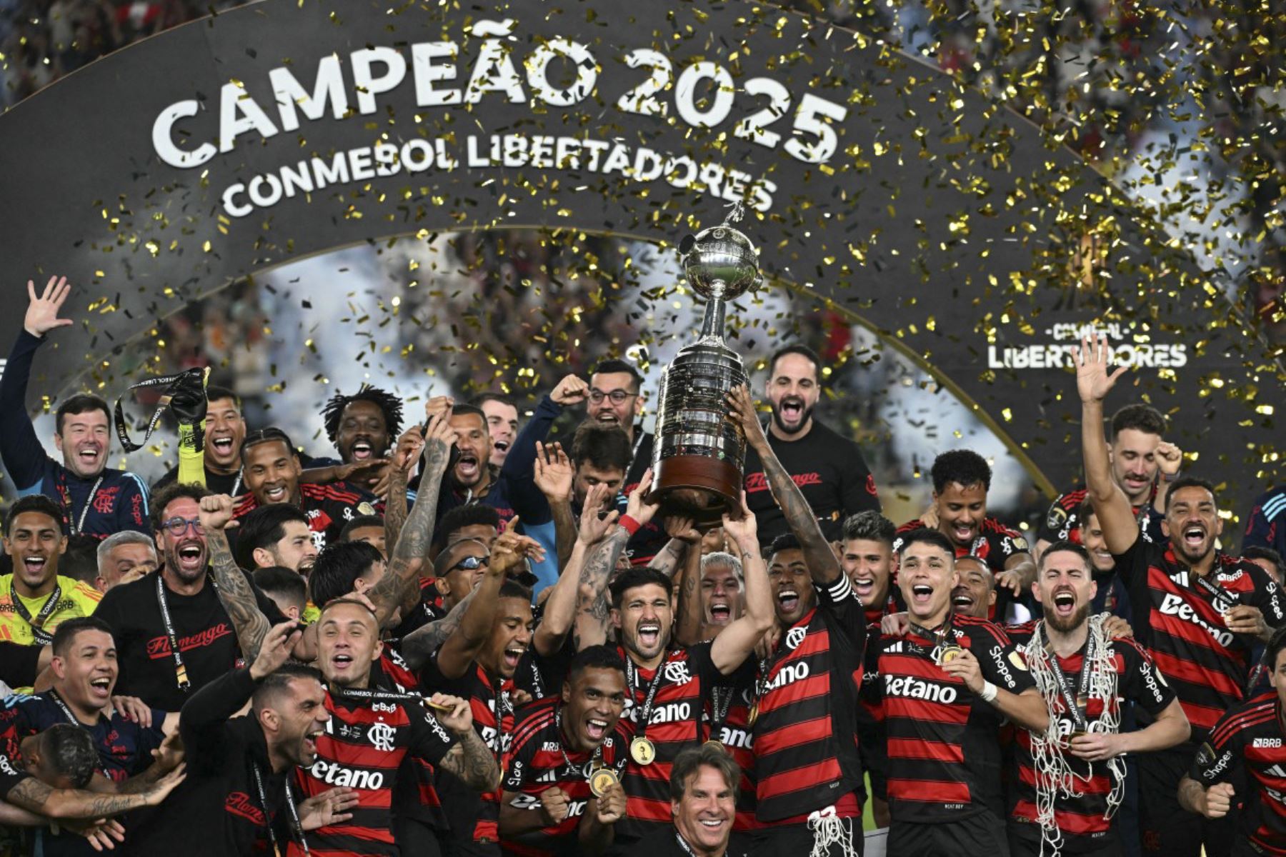 El delantero del Flamengo, Bruno Henrique, y el centrocampista uruguayo, Giorgian de Arrascaeta, levantan el trofeo con sus compañeros de equipo después de ganar el partido final de fútbol de la Copa Libertadores brasileña entre Palmeiras y Flamengo en el estadio Monumental 