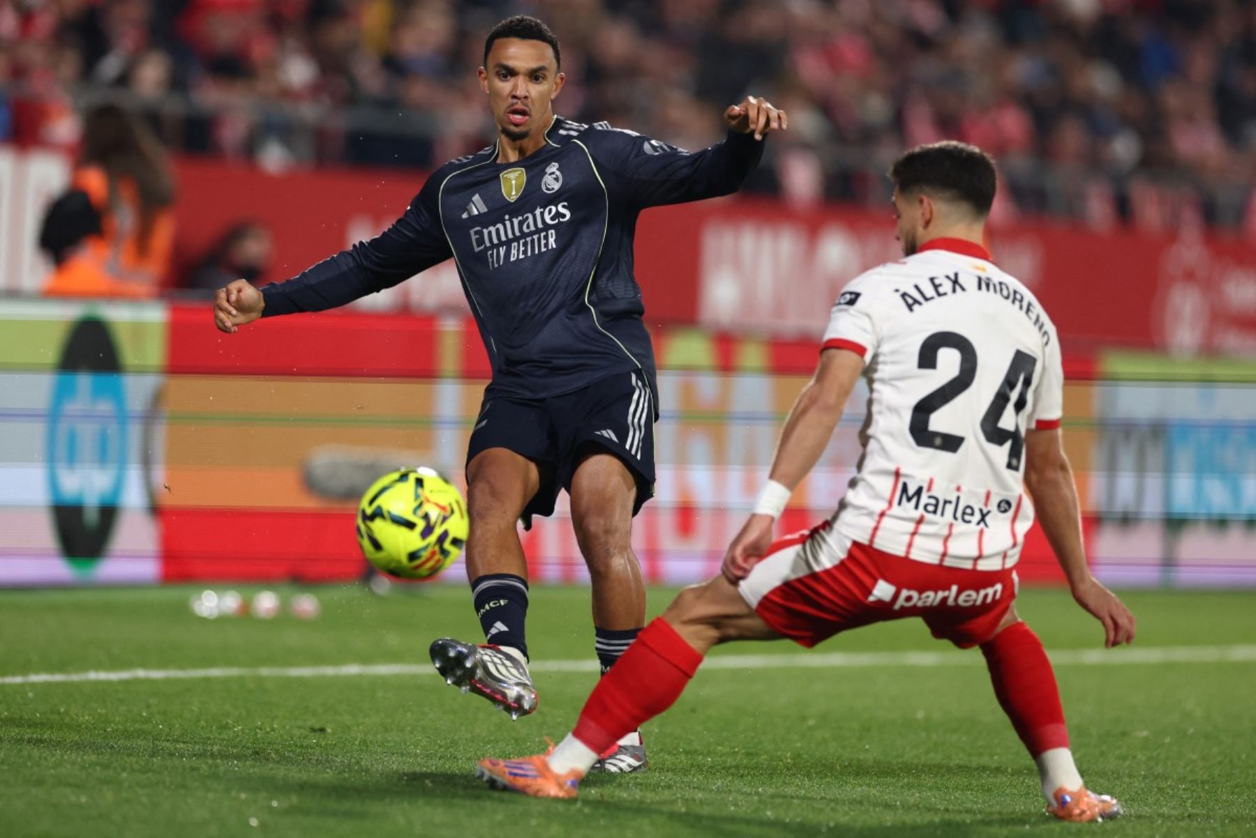 El defensor inglés #12 del Real Madrid, Trent Alexander-Arnold, es atacado por el defensor español #24 del Girona, Alexandre Moreno, durante el partido de fútbol de la liga española entre el Girona FC y el Real Madrid CF en el estadio Montilivi de Girona el 30 de noviembre de 2025. (Foto de Josep LAGO / AFP)