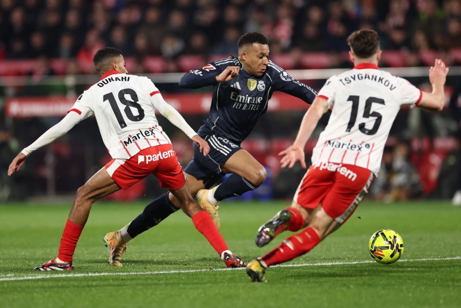 El centrocampista marroquí del Girona #18 Azzedine Ounahi, el delantero francés del Real Madrid #10 Kylian Mbappe y el centrocampista ucraniano del Girona #15 Viktor Tsygankov luchan por el balón durante el partido de fútbol de la liga española entre el Girona FC y el Real Madrid CF en el estadio Montilivi de Girona el 30 de noviembre de 2025. (Foto de Josep LAGO / AFP)