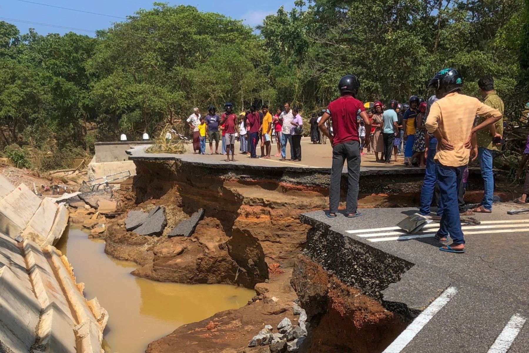 La gente se reúne alrededor del puente Deduru Oya, que se derrumbó tras las inundaciones en Kurunegala AFP