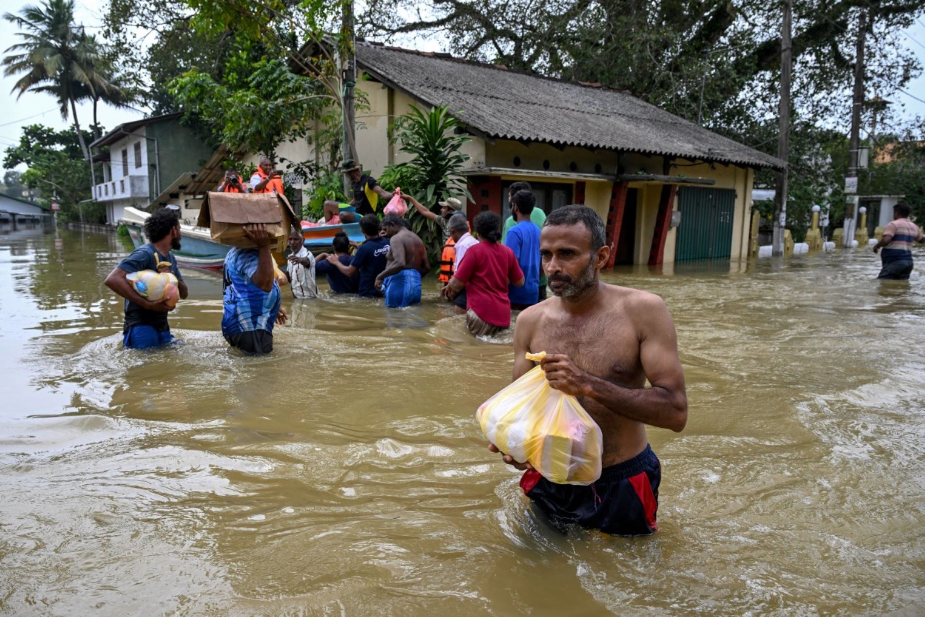 Los residentes cargan sus pertenencias mientras caminan a través de una zona inundada después de fuertes lluvias en Wellampitiya, en las afueras de Colombo. AFP