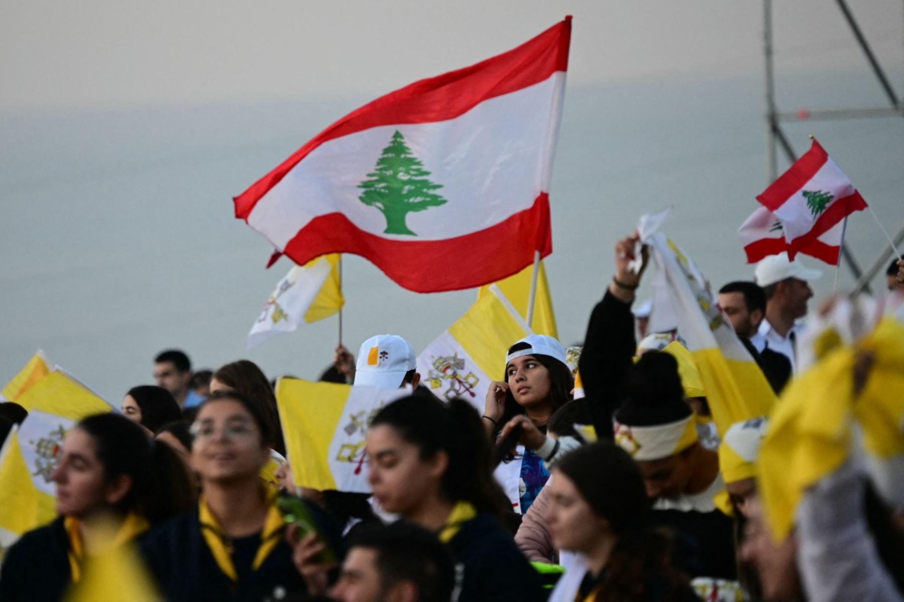 Los jóvenes ondean banderas libanesas y del Vaticano mientras esperan al Papa en el Patriarcado Maronita en Bkerke, al norte de la capital Beirut. AFP