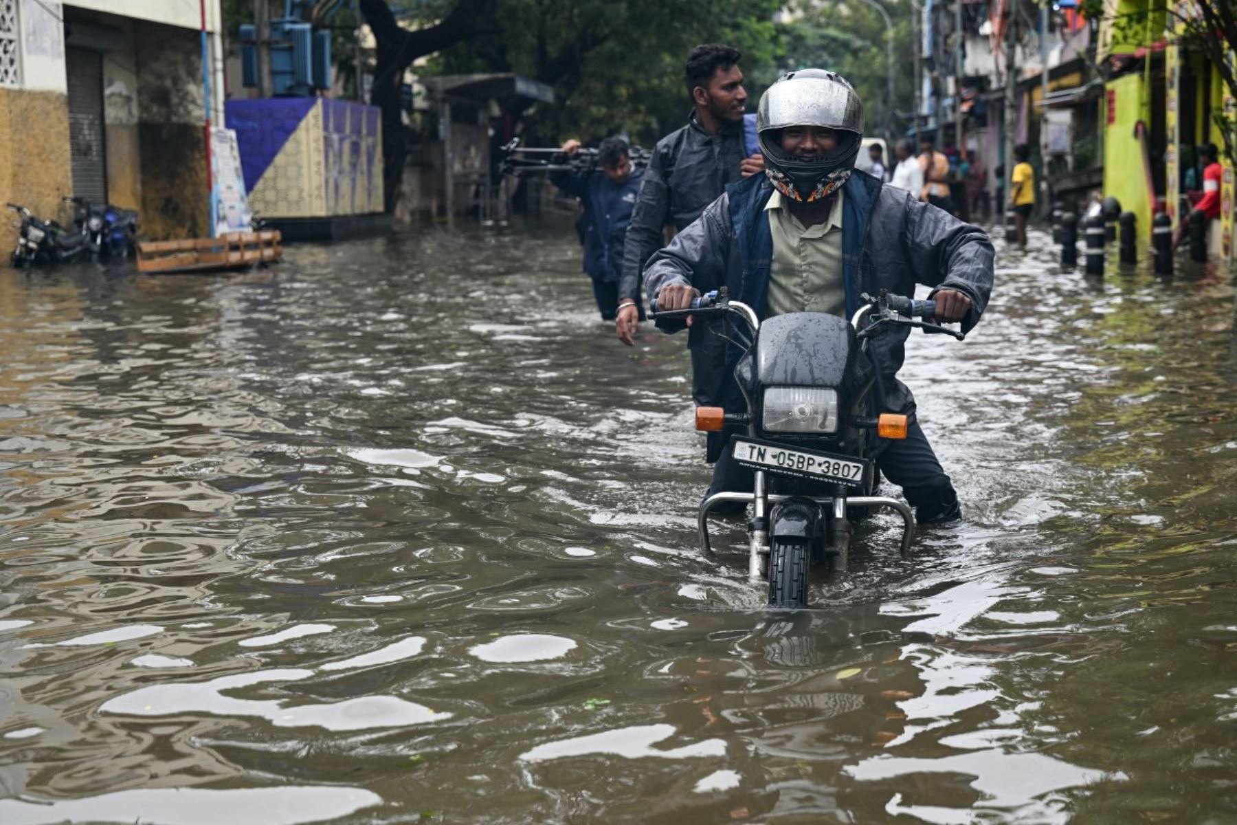 Un viajero camina a través de las inundaciones provocadas por el ciclón Ditwah en Chennai. Foto: AFP