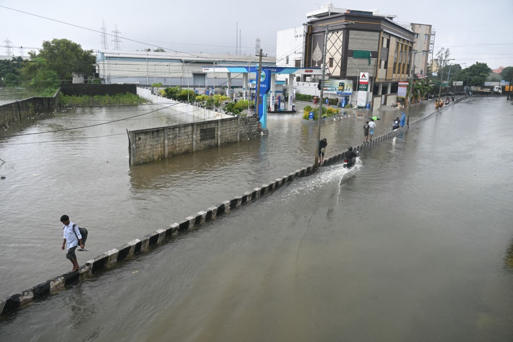 La gente camina a través de las aguas inundadas, en medio de fuertes lluvias debido al ciclón Ditwah, en las afueras de Chennai.  AFP