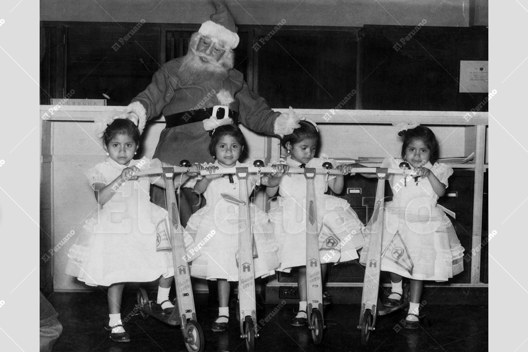 Lima – 20  diciembre 1956 / Un grupo de niñas posa  junto a Papá Noel, quien les ha entregado modernos scooters como regalo navideño. Foto: Archivo Histórico de El Peruano
