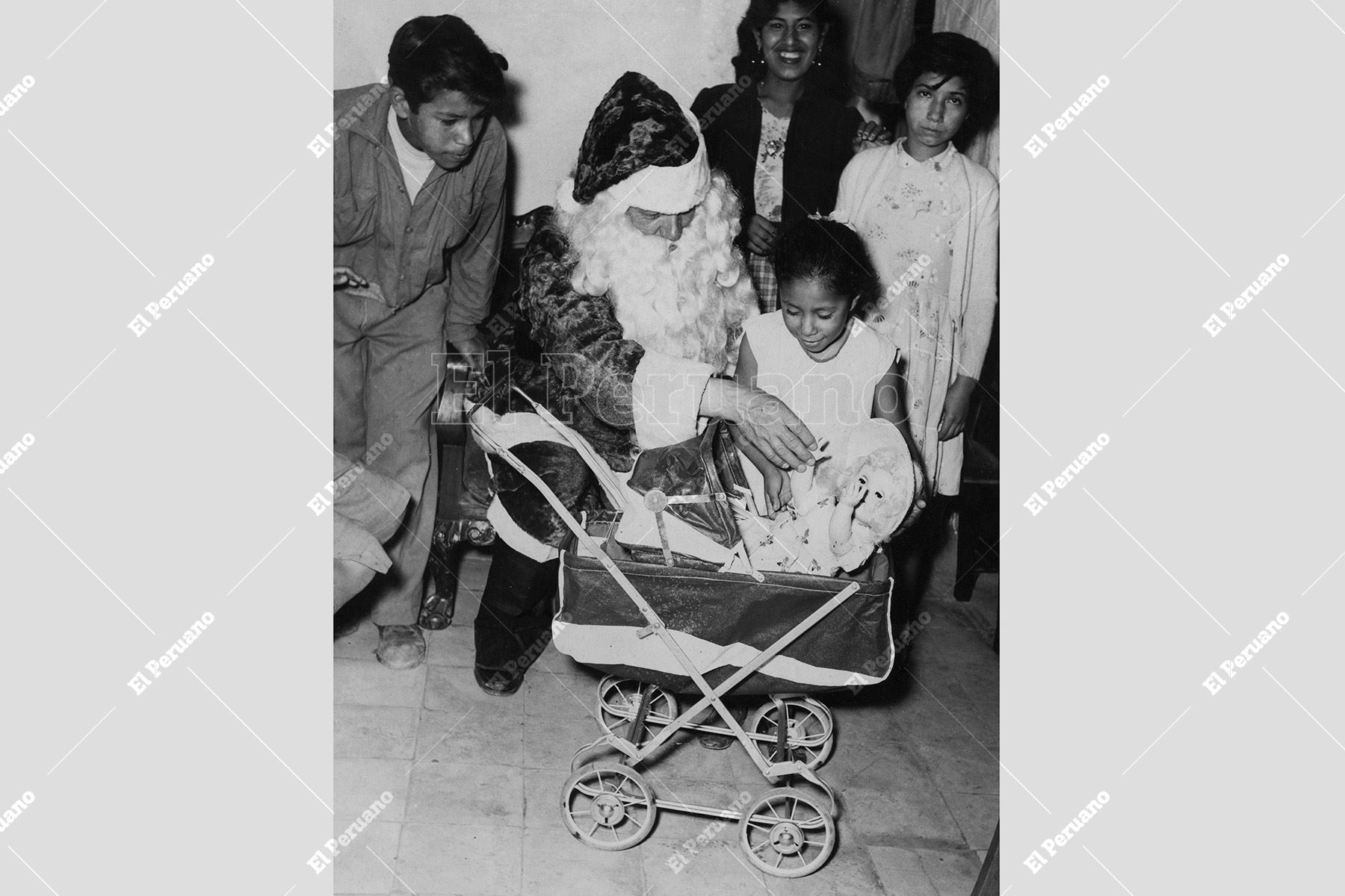 Lima - 21 diciembre 1955 / Hasta el populoso barrio de Azcona, llegó el legendario Papa Noel de Panagra, llevando un regalo a una niña que le dirigió una carta por Navidad, la mejor escrita, y en la que le pedía un cochecito para "pasear a su muñeca". Foto: Archivo Histórico de El Peruano