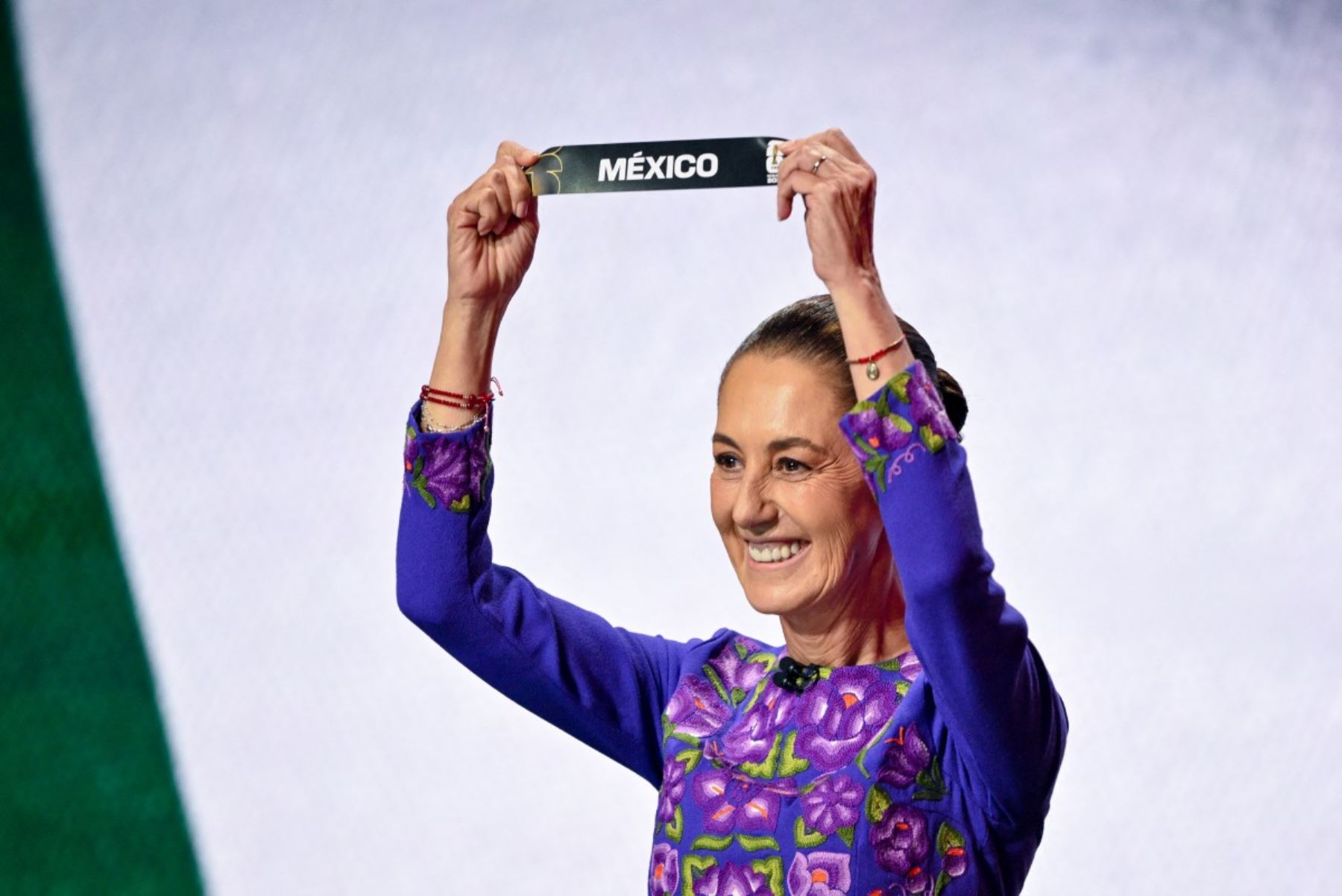 La presidenta de México, Claudia Sheinbaum, muestra la tarjeta que dice México durante el sorteo para la Copa Mundial de Fútbol de la FIFA 2026 que se celebra en Estados Unidos, Canadá y México, en el Kennedy Center, en Washington, D.C. AFP