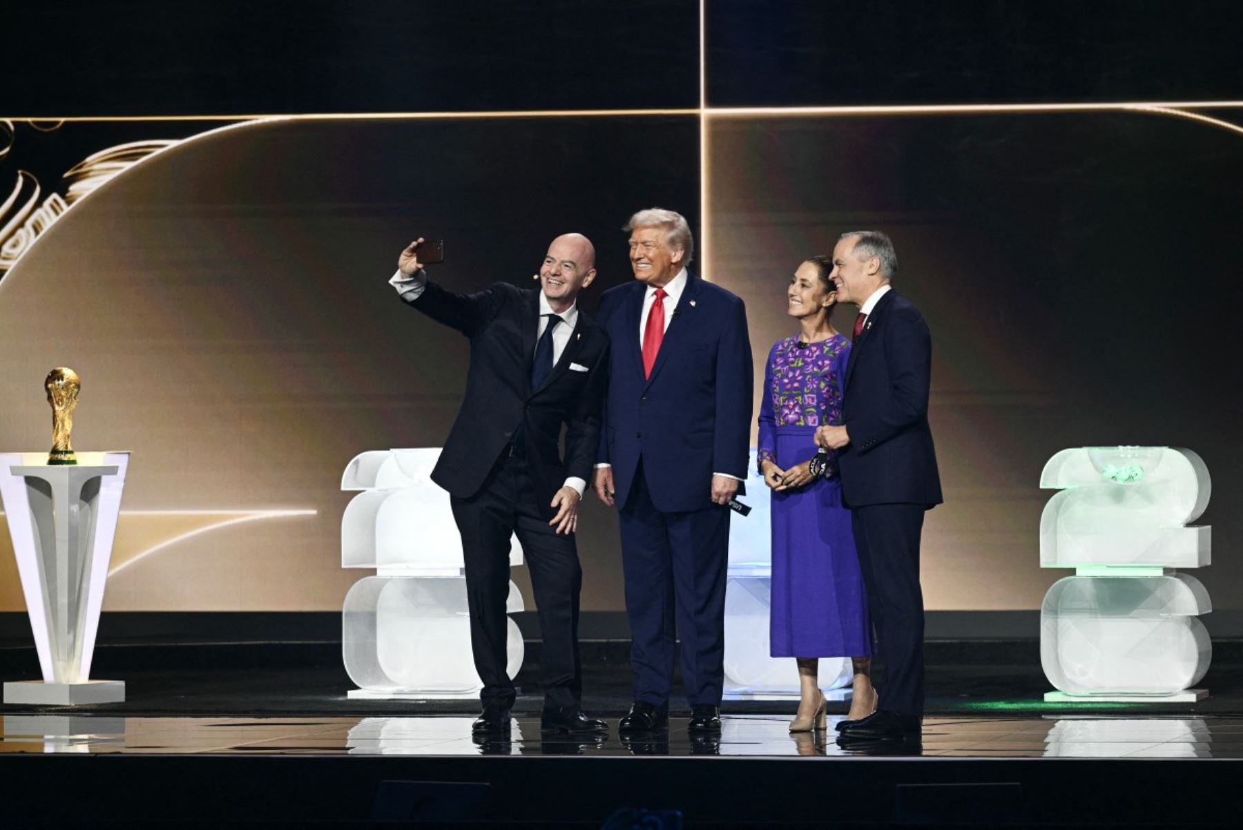 El presidente de la FIFA, Gianni Infantino, el presidente de Estados Unidos, Donald Trump, la presidenta de México, Claudia Sheinbaum, y el primer ministro de Canadá, Mark Carney, se toman una selfie en el escenario durante el sorteo de la Copa Mundial de Fútbol de la FIFA 2026 que se lleva a cabo en Estados Unidos, Canadá y México, en el Kennedy Center, en Washington, DC. AFP