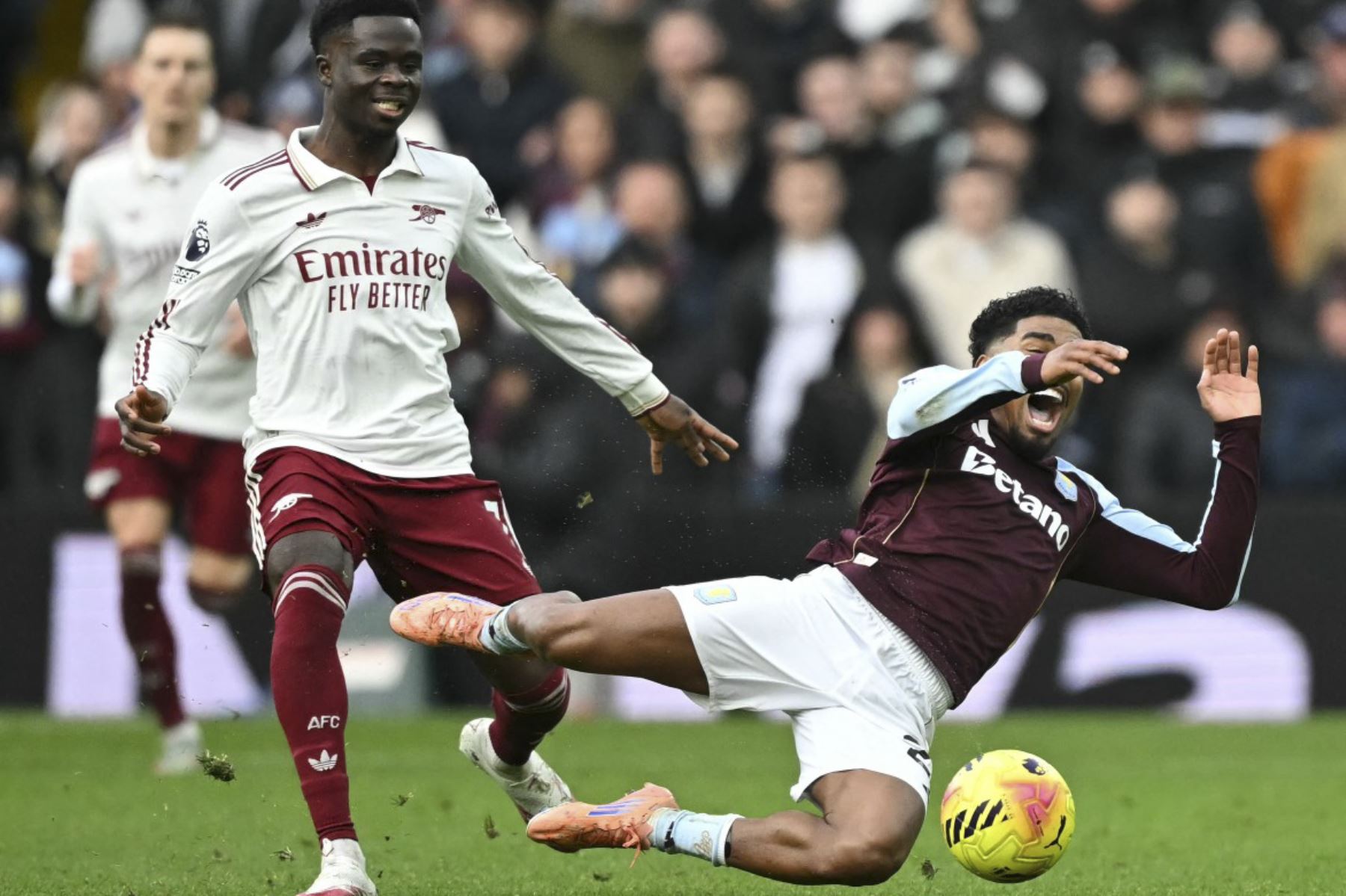 El centrocampista inglés del Arsenal #07 Bukayo Saka comete una falta al defensor holandés #22 del Aston Villa, Ian Maatsen, durante el partido de fútbol de la Premier League inglesa entre el Aston Villa y el Arsenal en el Villa Park, en Birmingham, centro de Inglaterra, el 6 de diciembre de 2025. (Foto de JUSTIN TALLIS/AFP)