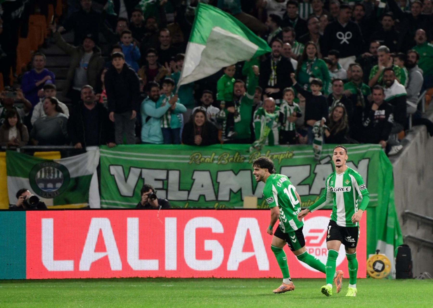 El delantero brasileño del Real Betis #07 Antony celebra con el delantero marroquí del Real Betis #10 Abde Ezzalzouli (izquierda) anotando el primer gol de su equipo durante el partido de fútbol de la liga española entre el Real Betis y el FC Barcelona en el Estadio Benito Villamarin de Sevilla el 6 de diciembre de 2025. (Foto de CRISTINA QUICLER / AFP)