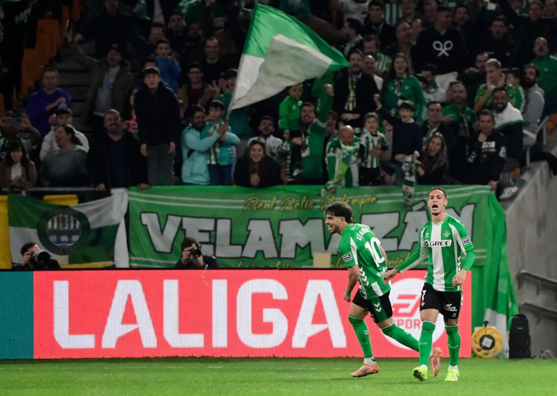 El delantero brasileño del Real Betis #07 Antony celebra con el delantero marroquí del Real Betis #10 Abde Ezzalzouli (izquierda) anotando el primer gol de su equipo durante el partido de fútbol de la liga española entre el Real Betis y el FC Barcelona en el Estadio Benito Villamarin de Sevilla el 6 de diciembre de 2025. (Foto de CRISTINA QUICLER / AFP)