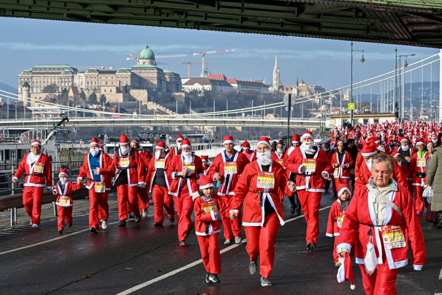 Los participantes con disfraces de Papá Noel participan en la tradicional carrera de Papá Noel a lo largo del río Danubio en Budapest, Hungría, el 7 de diciembre de 2025. Alrededor de cinco mil participantes participaron en la carrera para tres categorías: familias con niños, aficionados y corredores profesionales. (Foto de Attila KISBENEDEK / AFP)