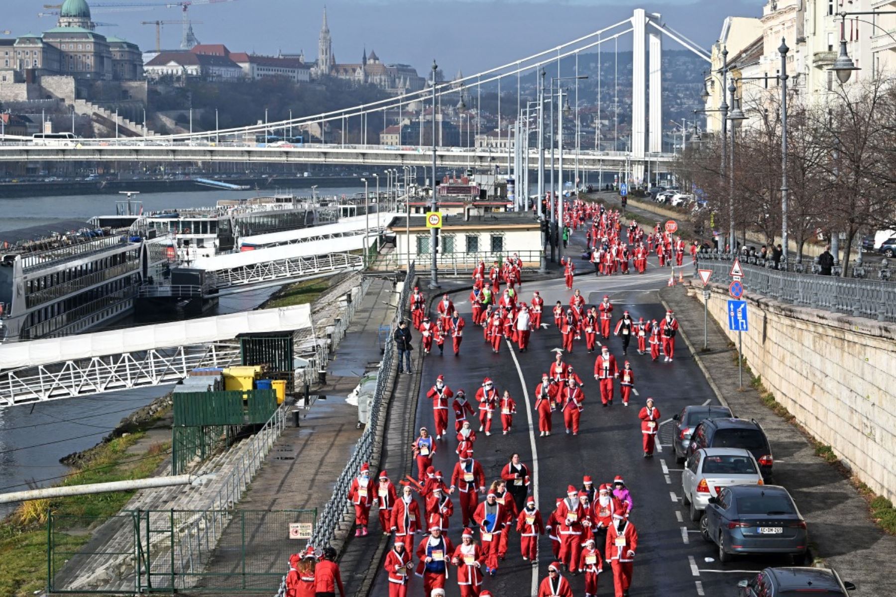 Los participantes con disfraces de Papá Noel participan en la tradicional carrera de Papá Noel a lo largo del río Danubio en Budapest, Hungría, el 7 de diciembre de 2025. Alrededor de cinco mil participantes participaron en la carrera para tres categorías: familias con niños, aficionados y corredores profesionales. (Foto de Attila KISBENEDEK / AFP)