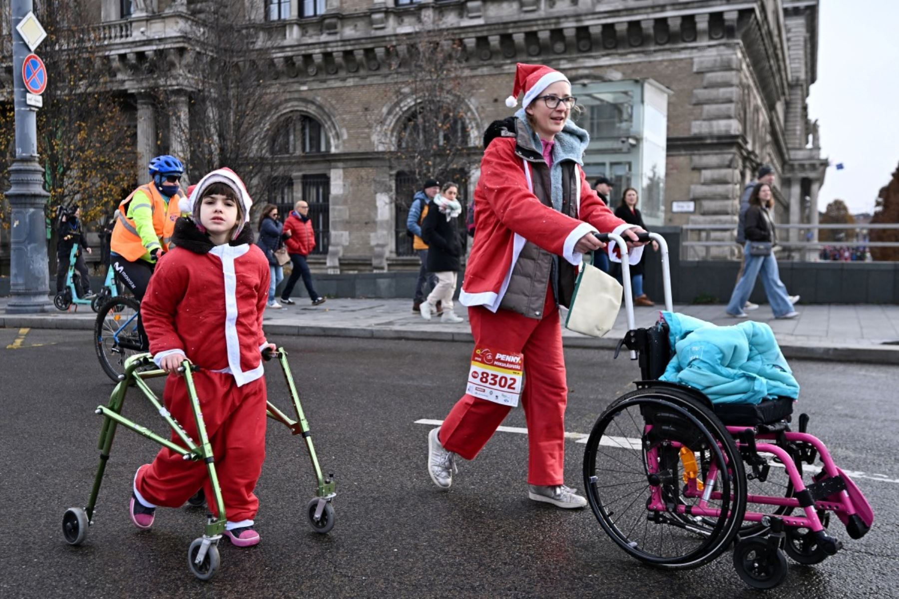 Los participantes con disfraces de Papá Noel participan en la tradicional carrera de Papá Noel a lo largo del río Danubio en Budapest, Hungría, el 7 de diciembre de 2025. Alrededor de cinco mil participantes participaron en la carrera para tres categorías: familias con niños, aficionados y corredores profesionales. (Foto de Attila KISBENEDEK / AFP)