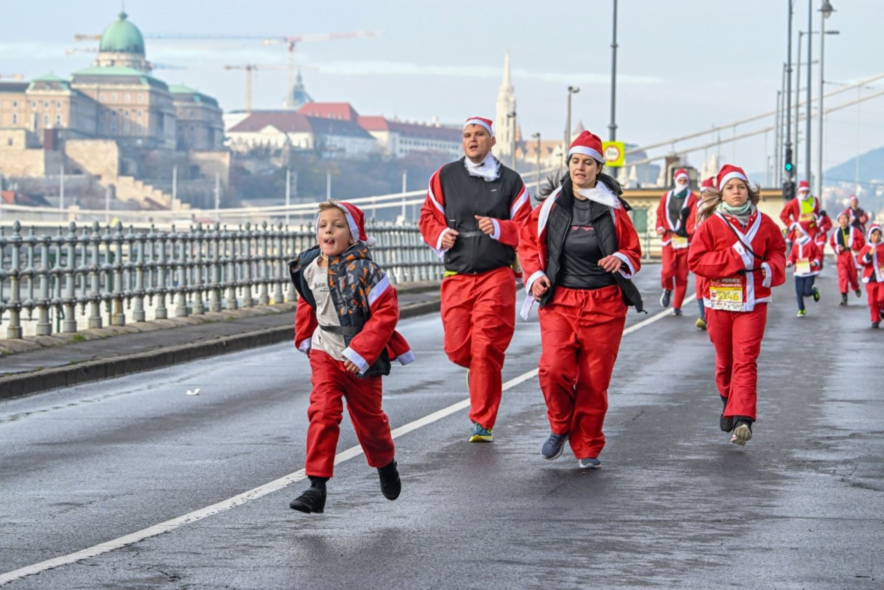 Los participantes con disfraces de Papá Noel participan en la tradicional carrera de Papá Noel a lo largo del río Danubio en Budapest, Hungría, el 7 de diciembre de 2025. Alrededor de cinco mil participantes participaron en la carrera para tres categorías: familias con niños, aficionados y corredores profesionales. (Foto de Attila KISBENEDEK / AFP)