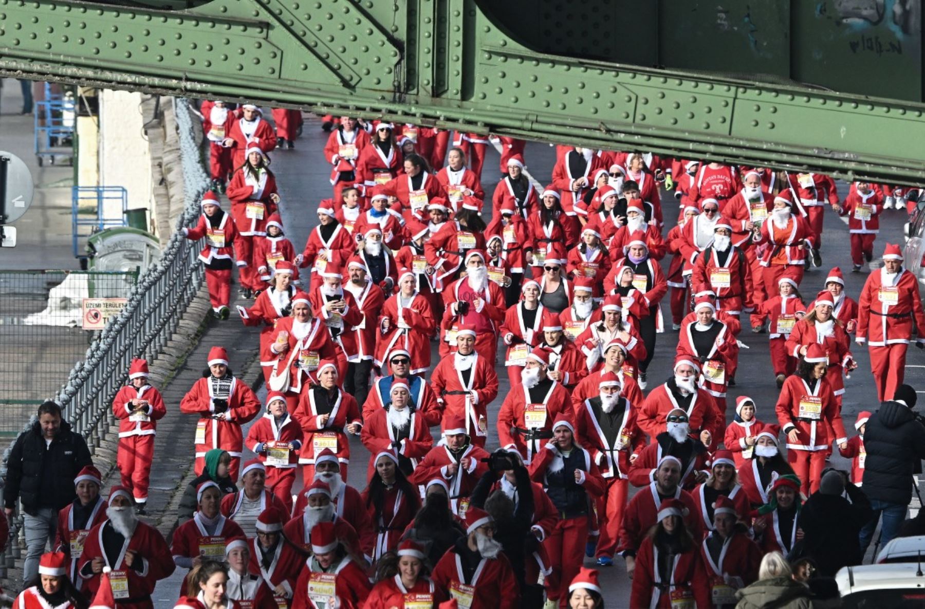 Los participantes con disfraces de Papá Noel participan en la tradicional carrera de Papá Noel a lo largo del río Danubio en Budapest, Hungría, el 7 de diciembre de 2025. Alrededor de cinco mil participantes participaron en la carrera para tres categorías: familias con niños, aficionados y corredores profesionales. (Foto de Attila KISBENEDEK / AFP)