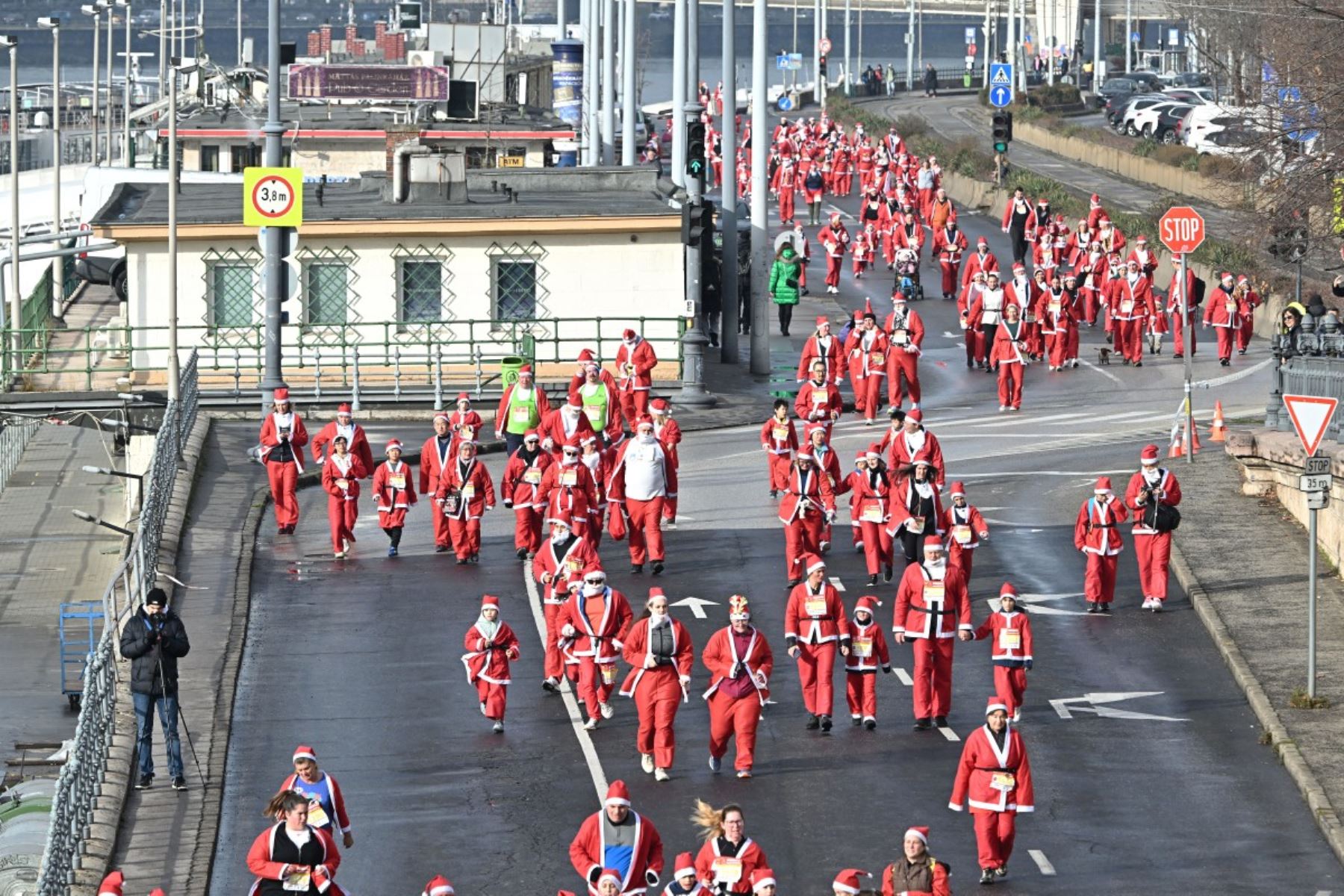 Los participantes con disfraces de Papá Noel participan en la tradicional carrera de Papá Noel a lo largo del río Danubio en Budapest, Hungría, el 7 de diciembre de 2025. Alrededor de cinco mil participantes participaron en la carrera para tres categorías: familias con niños, aficionados y corredores profesionales. (Foto de Attila KISBENEDEK / AFP)