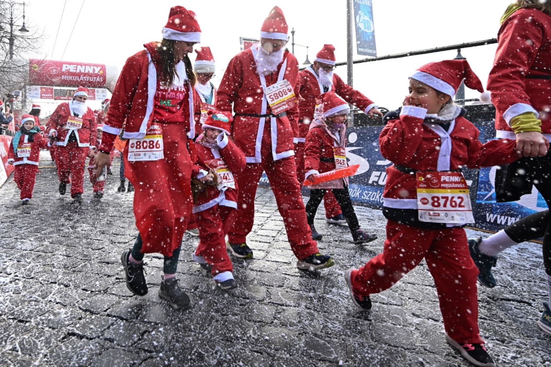 Los participantes con disfraces de Papá Noel participan en la tradicional carrera de Papá Noel a lo largo del río Danubio en Budapest, Hungría, el 7 de diciembre de 2025. Alrededor de cinco mil participantes participaron en la carrera para tres categorías: familias con niños, aficionados y corredores profesionales. (Foto de Attila KISBENEDEK / AFP)