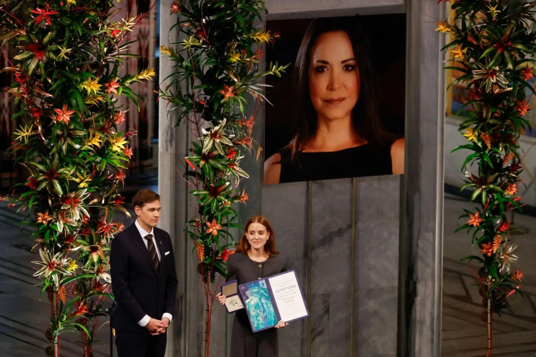 Ana Corina Sosa, hija de la líder opositora venezolana María Corina Machado, recibe el Premio Nobel de la Paz para su madre de manos del presidente del Comité Noruego del Nobel, Jorgen Watne Frydnes  en la ceremonia del Premio Nobel de la Paz en el Ayuntamiento de Oslo. AFP