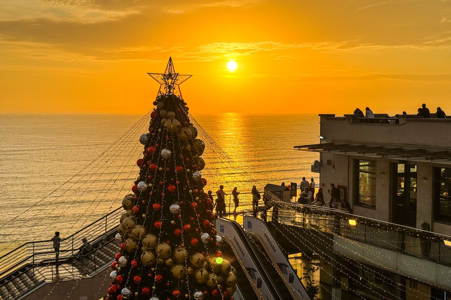 El gran árbol de Larcomar adorna con espíritu navideño la imponente vista del malecón mientras el sol se oculta. Foto: ANDINA/Ricardo Cuba