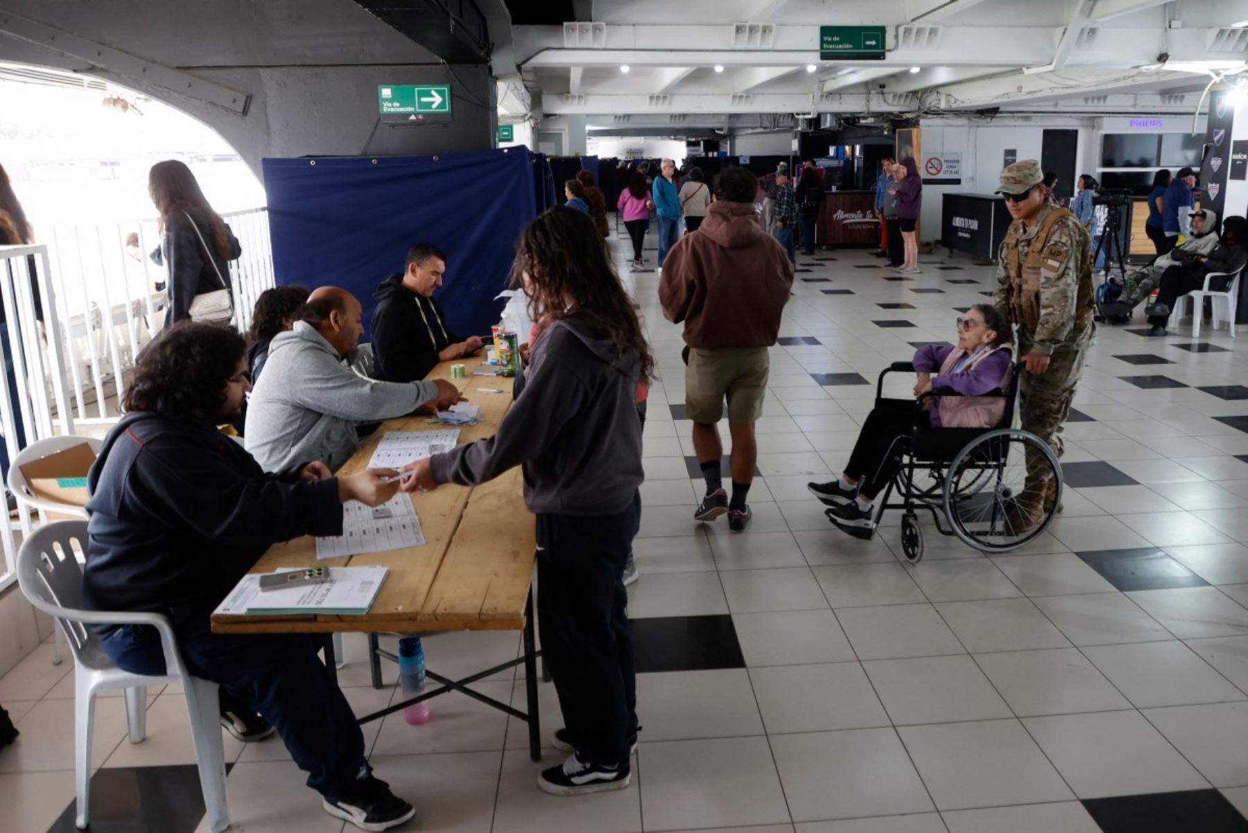 La gente cola para votar durante la segunda vuelta de las elecciones presidenciales en el Estadio Monumental Colo-Colo en Santiago, Chile, el 14 de diciembre de 2025. Los chilenos se dirigen a las urnas para una resección presidencial entre Jeannette Jara, una comunista respaldada por una amplia coalición de izquierda, y José Antonio Kast, un devoto político de extrema derecha que promete una línea dura en seguridad y migración. (Foto de Raúl BRAVO / AFP)