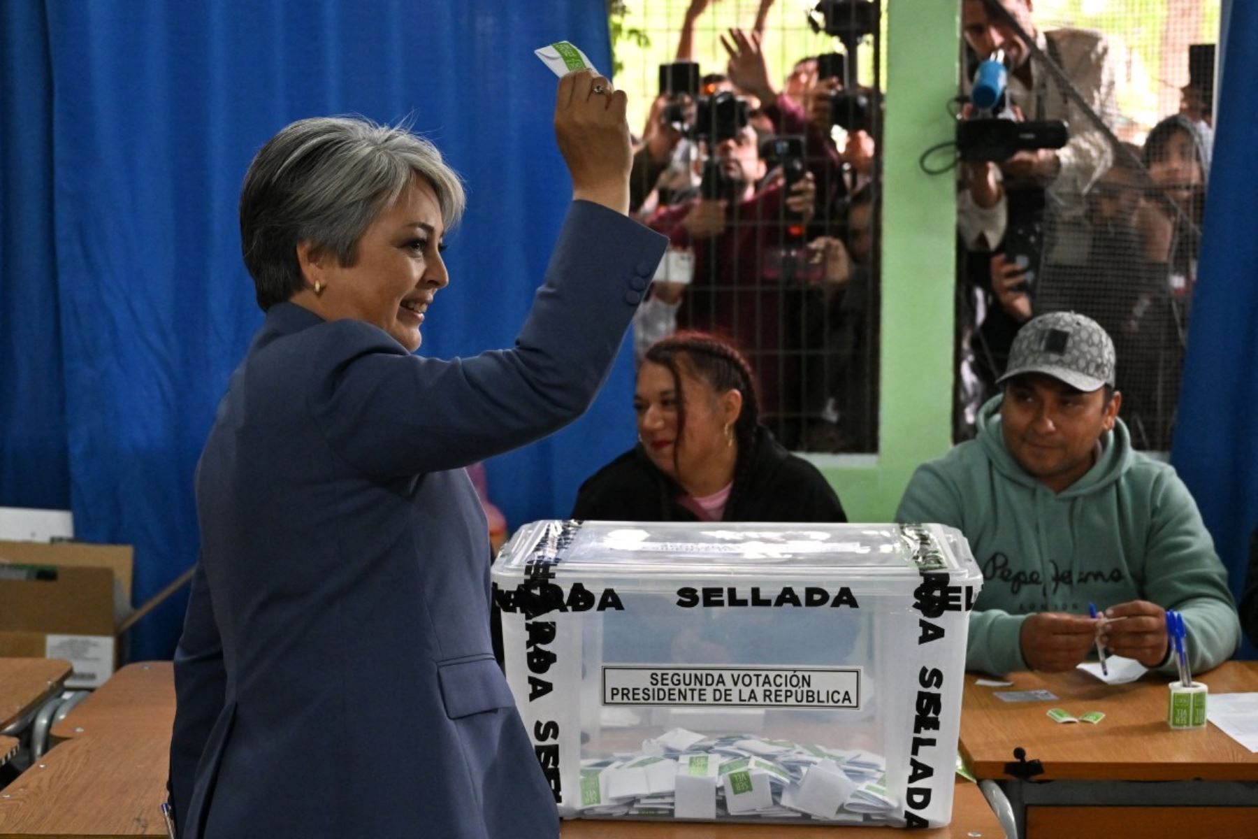 La candidata presidencial de Chile, Jeannette Jara, de la coalición Unidad por Chile, muestra su voto antes de emitir su voto durante la segunda vuelta de las elecciones presidenciales en Santiago el 14 de diciembre de 2025. Los chilenos se dirigen a las urnas para una resección presidencial entre Jeannette Jara, una comunista respaldada por una amplia coalición de izquierda, y José Antonio Kast, un devoto político de extrema derecha que promete una línea dura en seguridad y migración. (Foto de RODRIGO ARAN