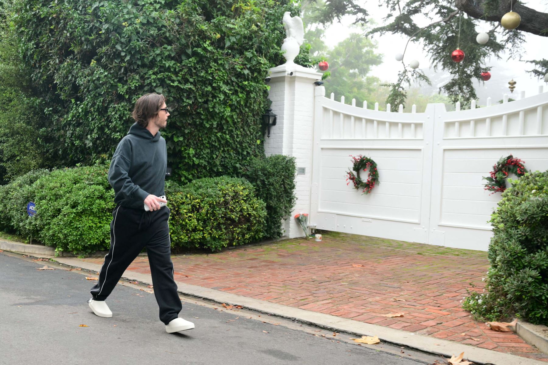 El asistente del actor y director estadounidense Rob Reiner, identificado solo como Rocco, camina fuera de la mansión de Reiner en el barrio de Brentwood de Los Ángeles, California, el 15 de diciembre de 2025, después de que el director y su esposa, Michele Reiner, fueran encontrados muertos. Foto: AFP