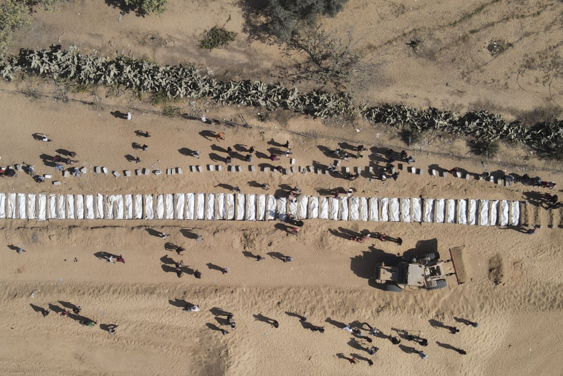 Esta vista aérea muestra a palestinos enterrando 54 cuerpos no identificados en un cementerio en Deir al-Balah, en el centro de la Franja de Gaza, el 22 de octubre de 2025, después de que Israel los devolviera bajo un acuerdo de alto el fuego negociado por Estados Unidos. (Foto de AFP)