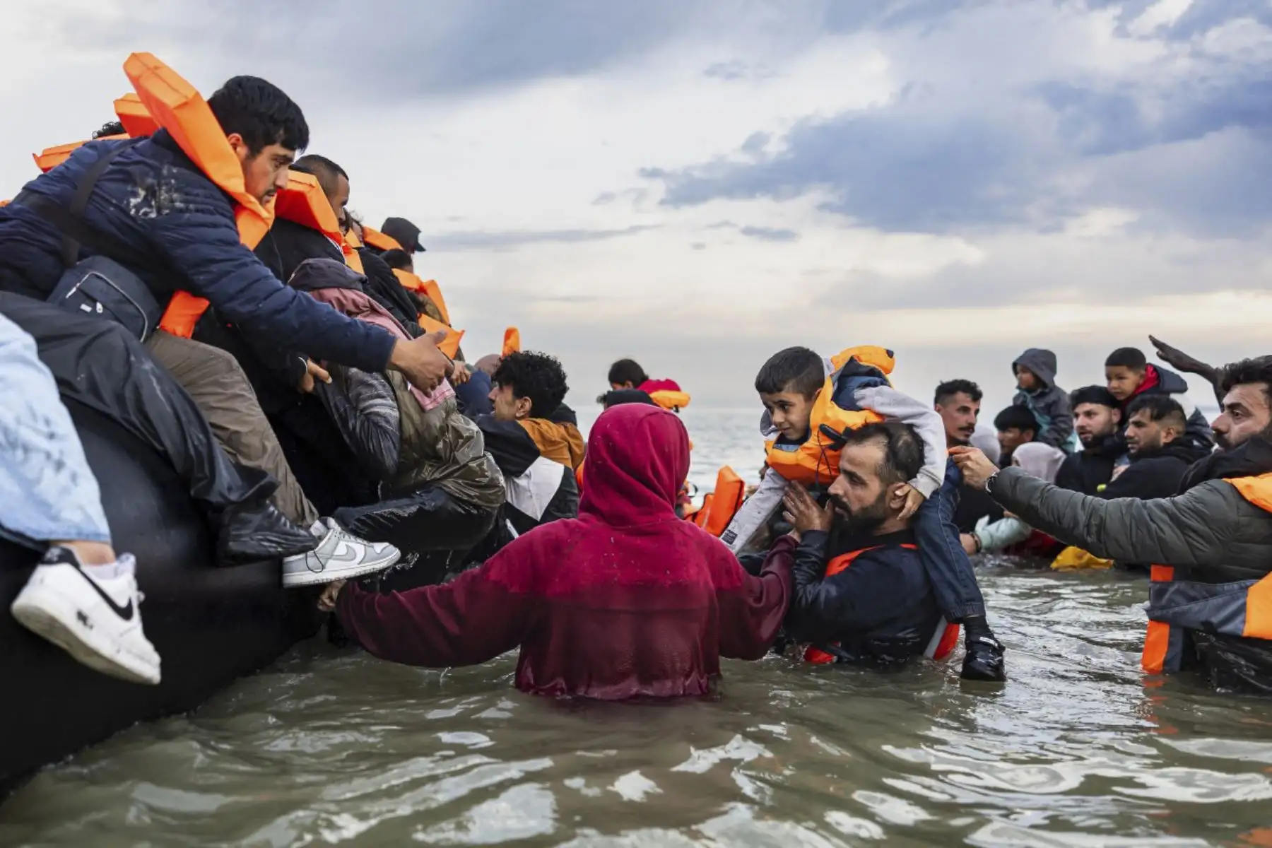 Los migrantes intentan abordar un barco de contrabandista en un intento de cruzar el Canal de la Mancha desde la playa de Gravelines, al norte de Francia, el 12 de agosto de 2025. (Foto de Sameer Al-DOUMY / AFP)