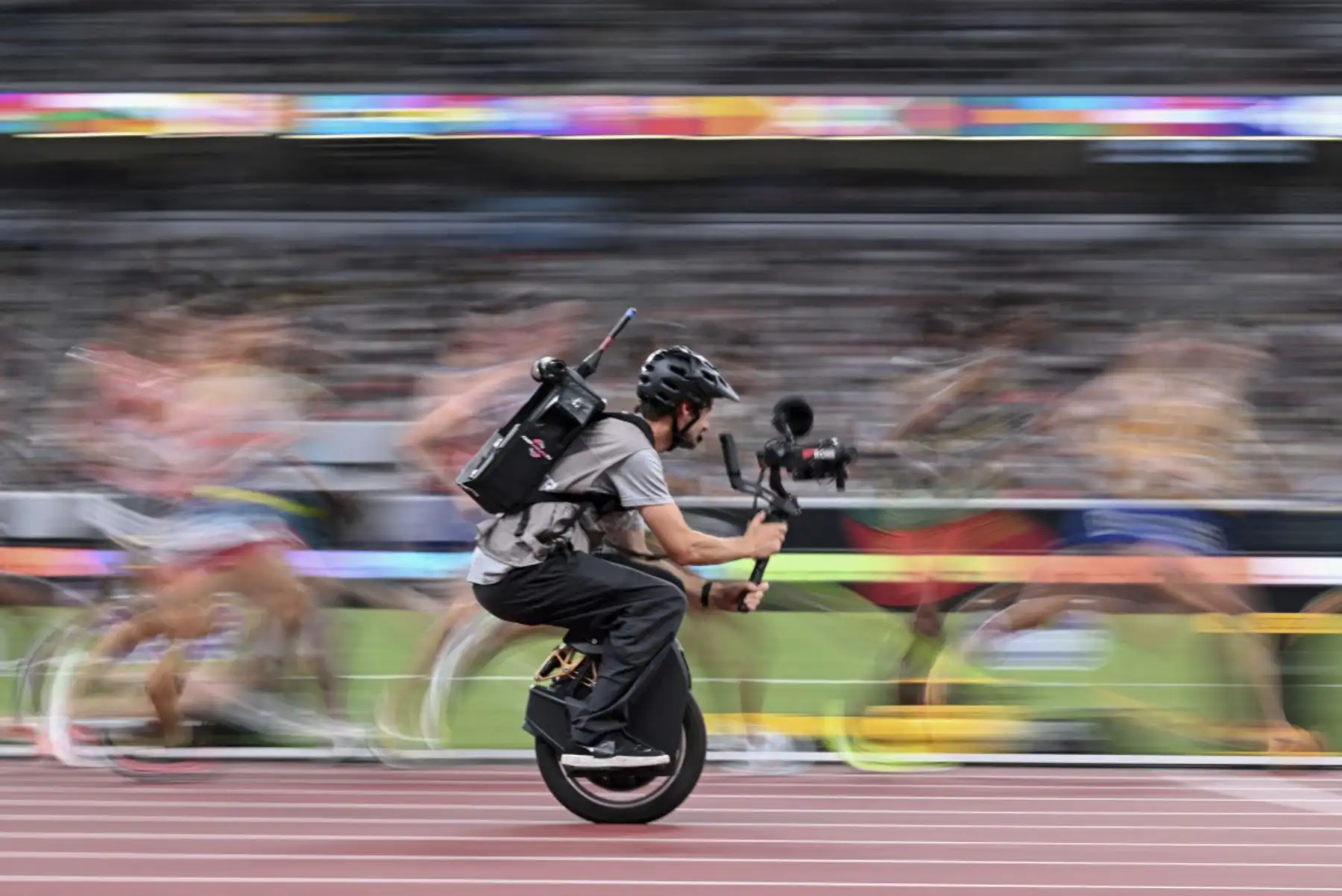 Un camarógrafo en un monociclo filma a los atletas en acción mientras compiten en la final de 10000 m masculino durante el Campeonato Mundial de Atletismo en Tokio el 14 de septiembre de 2025. (Foto de Kirill KUDRYAVTSEV / AFP)
